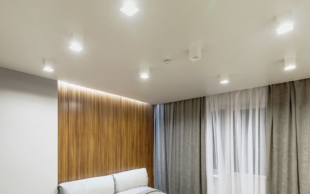 Sufit napinany z oświetleniem LED i zasłonami w salonie