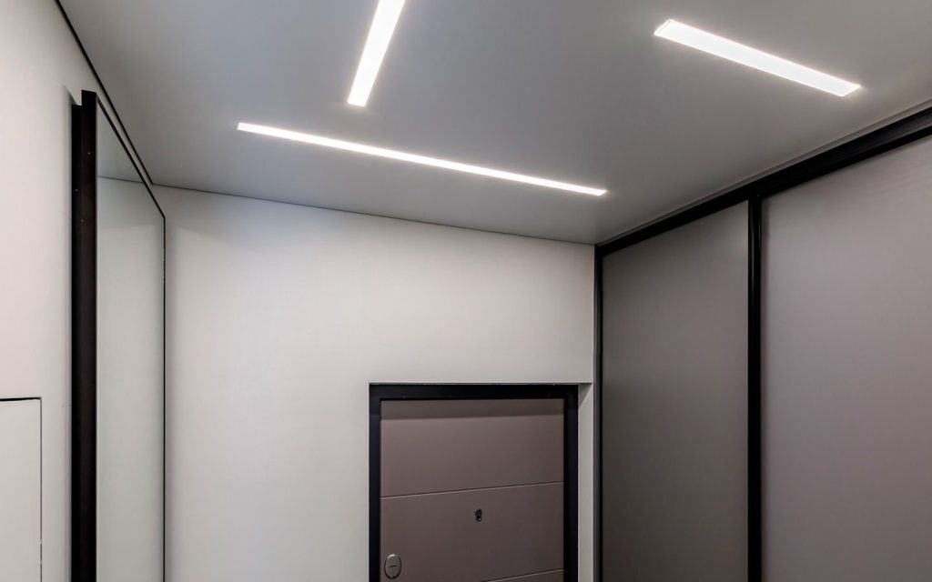 Sufit napinany w przedpokoju z nowoczesnymi liniami świetlnymi LED
